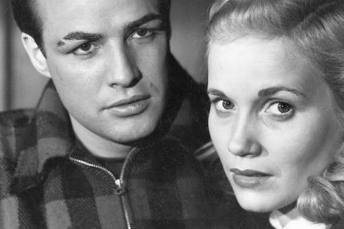 Marlon Brando with clipped eyebrow and flannel jacket as Terry Malloy with Eve Marie Saint with blonde hair and a worried expression