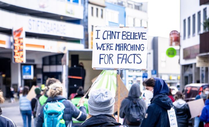 Protestor holds a sign 'I can't believe we're marching for facts'