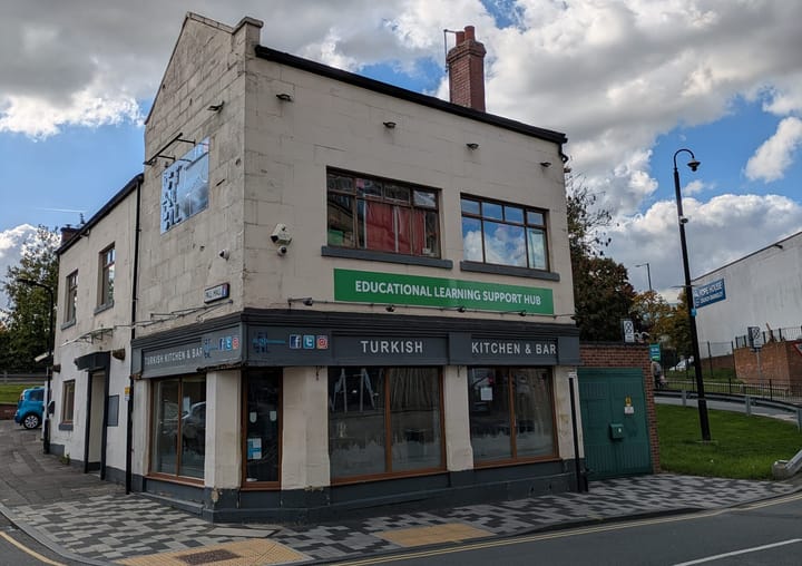 A building with a Turkish restaurant below and the Educational Learning and Support Hub (with a green sign) above. 